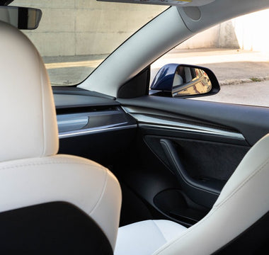 Tesla Model 3 with white interior seating and carbon door panels